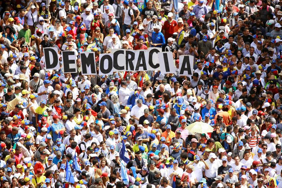 Manifestantes contrários ao governo do presidente venezuelano Nicolás Maduro carregam letras que formam a palavra "democracia"